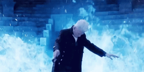 A Man In A Suit Is Standing In Front Of A Wall Of Fire And Smoke . GIF
