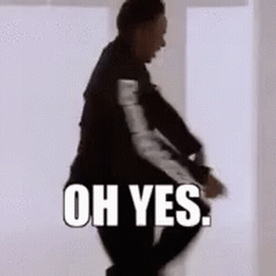 A Man In A Suit Is Standing In Front Of A White Wall With The Words Oh Yes Written On It . GIF