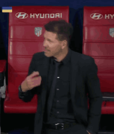 A Man In A Suit Is Standing In Front Of Red Seats GIF