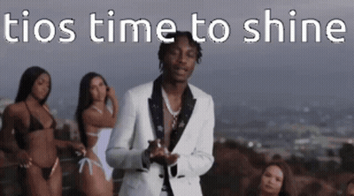A Man In A Suit Is Standing In Front Of Three Bikinis . GIF