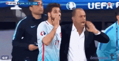 A Man In A Suit Is Standing Next To A Man In A Blue Shirt With The Number 17 On It GIF