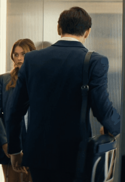 A Man In A Suit Is Standing Next To A Woman In A Suit GIF