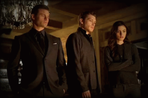 A Man In A Suit Is Standing Next To A Woman GIF