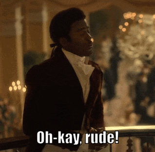 A Man In A Suit Is Standing On A Balcony And Says Oh-Kay Rude GIF