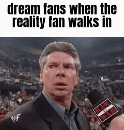 A Man In A Suit Is Talking Into A Microphone With The Words Dream Fans When The Reality Fan Walks In Below Him GIF