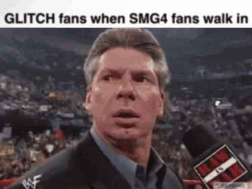 A Man In A Suit Is Talking Into A Microphone With The Words Glitch Fans When Smg4 Fans Walk In Below Him GIF