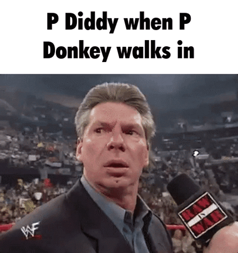 A Man In A Suit Is Talking Into A Microphone With The Words P Diddy When P Donkey Walks In . GIF