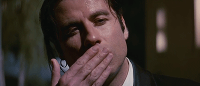 A Man In A Suit Is Talking On A Cell Phone And Covering His Mouth With His Hand . GIF