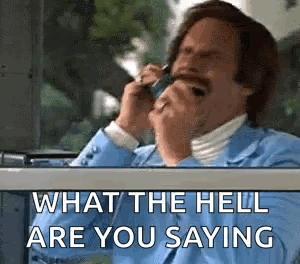 A Man In A Suit Is Talking On A Cell Phone . GIF