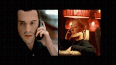 A Man In A Suit Is Talking On A Cell Phone Next To A Woman Sitting On A Couch Talking On A Cell Phone GIF