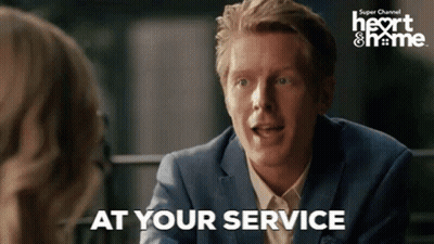 A Man In A Suit Is Talking To A Woman And Says " At Your Service " . GIF