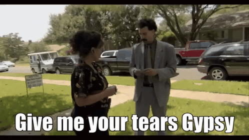 A Man In A Suit Is Talking To A Woman With The Words Give Me Your Tears Gypsy On The Bottom GIF
