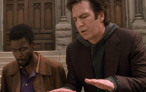 A Man In A Suit Is Talking To Another Man In Front Of A Building GIF