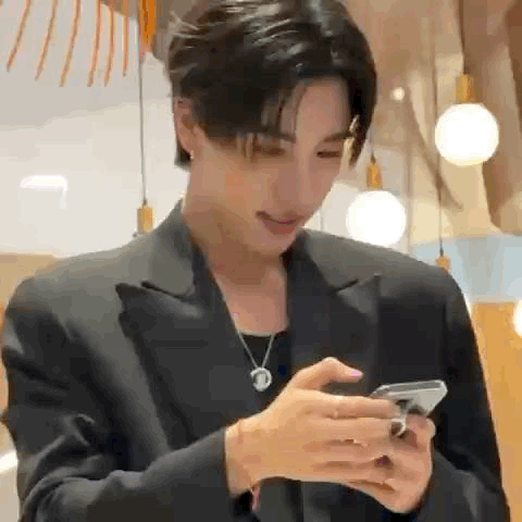 A Man In A Suit Is Using A Cell Phone . GIF
