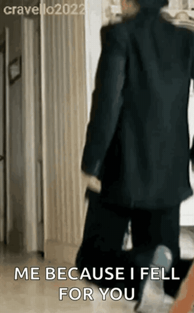 A Man In A Suit Is Walking Down A Hallway And Saying `` Me Because I Fell For You '' GIF