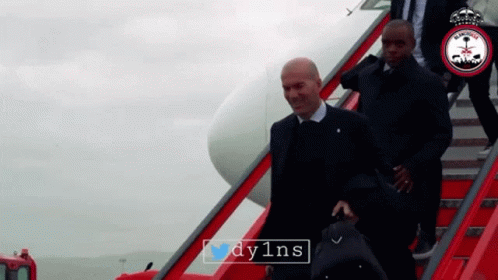 A Man In A Suit Is Walking Down A Set Of Red Stairs With The Hashtag Dy1ns On The Bottom GIF
