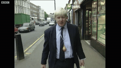 A Man In A Suit Is Walking Down A Street With A Bbc Logo On The Bottom Right GIF