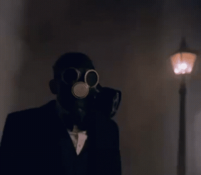 A Man In A Suit Is Wearing A Gas Mask And Holding A Gun . GIF