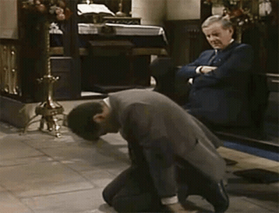 A Man In A Suit Kneels Down In Front Of Another Man GIF