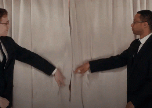 A Man In A Suit Reaches Out To Another Man In A Suit GIF