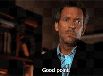 A Man In A Suit Says " Good Point " In Front Of A Bookshelf GIF