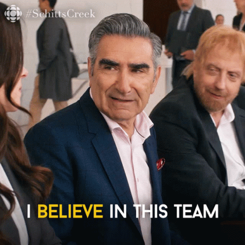 A Man In A Suit Says " I Believe In This Team " In Front Of A Group Of People GIF