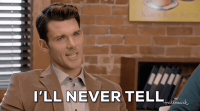 A Man In A Suit Says " I 'Ll Never Tell " In Front Of A Brick Wall GIF