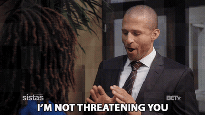 A Man In A Suit Says I 'M Not Threatening You To A Woman GIF