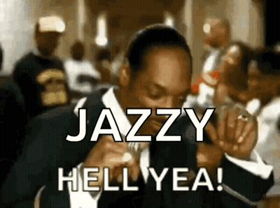 A Man In A Suit Says Jazzy Hell Yea In Front Of A Crowd Of People GIF