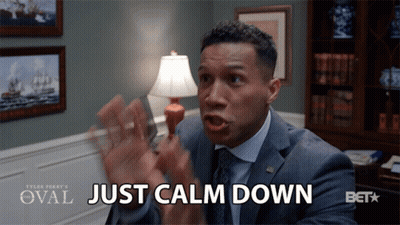 A Man In A Suit Says Just Calm Down In Front Of A Lamp GIF