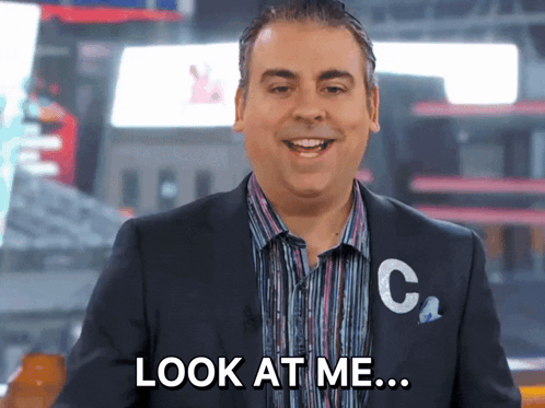 A Man In A Suit Says Look At Me While Smiling GIF