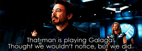 A Man In A Suit Says That Man Is Playing Galaga GIF