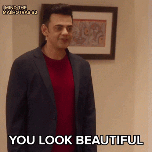 A Man In A Suit Says You Look Beautiful In Front Of A Framed Picture GIF