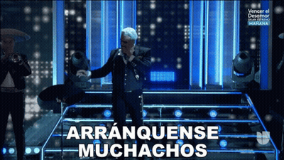 A Man In A Suit Singing Into A Microphone With Arranquense Muchachos Written Below Him GIF