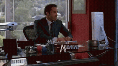 A Man In A Suit Sits At A Desk With A Sign On It That Says Immunity GIF