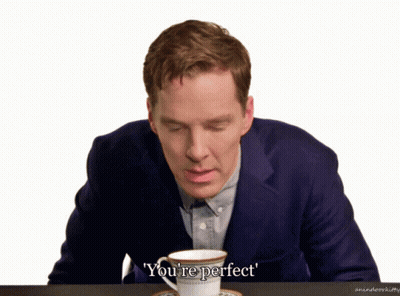 A Man In A Suit Sits At A Table With A Cup Of Coffee And The Words You 'Re Perfect Above Him GIF