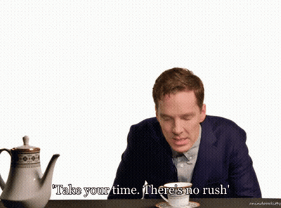 A Man In A Suit Sits At A Table With A Cup Of Tea And Says Take Your Time There 'S No Rush ' GIF