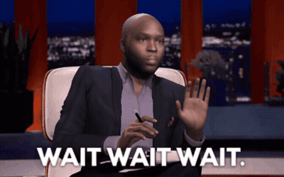 A Man In A Suit Sits In A Chair With The Words Wait Wait Wait Below Him GIF