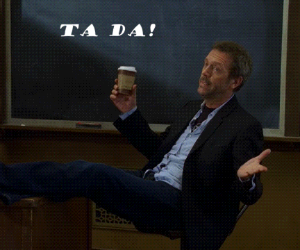 A Man In A Suit Sits In Front Of A Chalkboard That Says " Ta Da " GIF