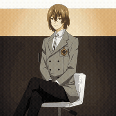 A Man In A Suit Sits On A Chair With His Legs Crossed GIF