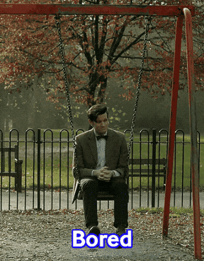A Man In A Suit Sits On A Swing With The Word Bored Below Him GIF