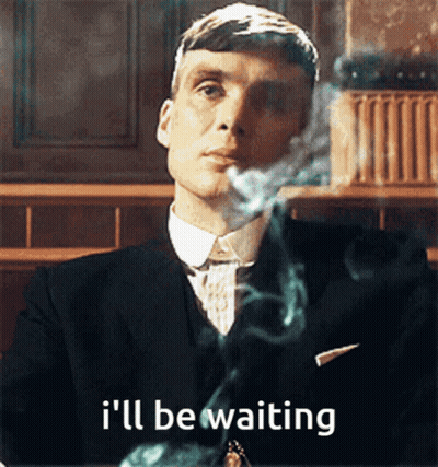 A Man In A Suit Smoking A Cigarette With The Words I 'Ll Be Waiting Behind Him GIF