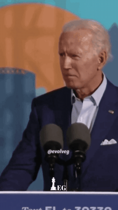 A Man In A Suit Stands At A Podium With The Word Evolveg On The Front GIF