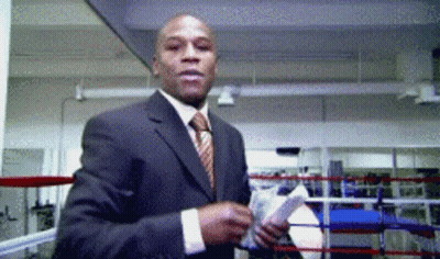 A Man In A Suit Stands In A Boxing Ring GIF