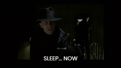 A Man In A Suit Stands In A Dark Room And Says Sleep Now GIF