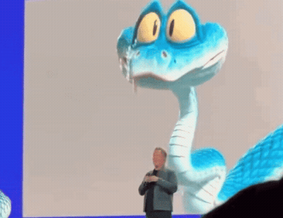 A Man In A Suit Stands In Front Of A Blue And White Cartoon Snake GIF