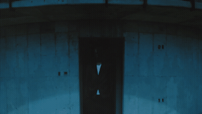 A Man In A Suit Stands In Front Of A Building With The Number 11 On The Door GIF