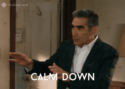 A Man In A Suit Stands In Front Of A Door With Calm Down Written On It GIF