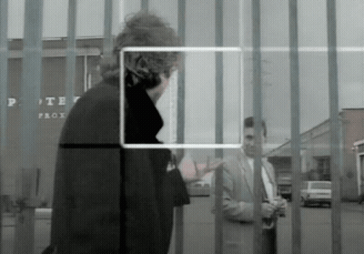 A Man In A Suit Stands In Front Of A Fence With A Sign That Says Porter Prox GIF
