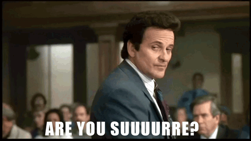 A Man In A Suit Stands In Front Of A Group Of People And Says Are You Suuuurre GIF